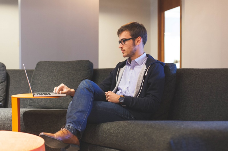 Man Relaxing on Couch with Laptop