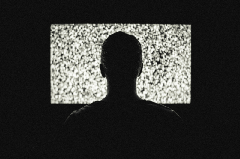 Person Sitting in front of TV Displaying Snow