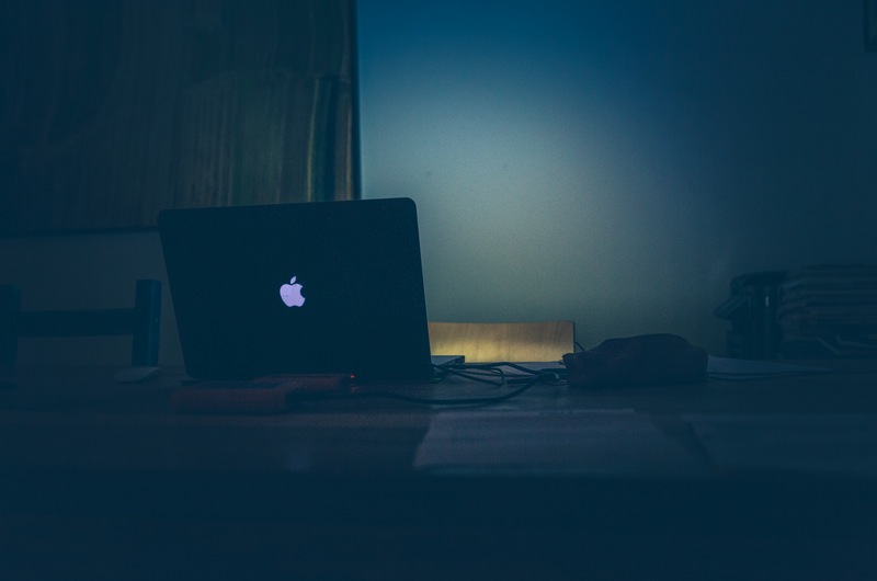 Macbook on Desk in Dark Room