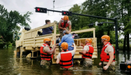 Texas National Guardsmen assist residents affected by flooding caused by Hurricane Harvey onto a military vehicle