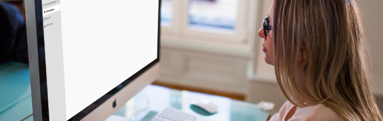 Woman in front of mac desktop with Finance Enterprise open