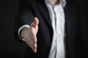 Person in suit with hand outstretched for a shake Person in suit with hand outstretched for a shake