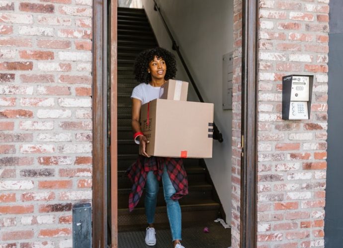 Woman carrying boxes out of a building