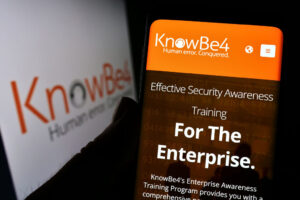 Person holding mobile phone with website of US security awareness company KnowBe4 Inc. on screen with logo