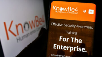 Person holding mobile phone with website of US security awareness company KnowBe4 Inc. on screen with logo